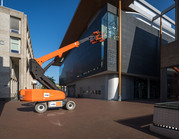 Telescoophoogwerker in actie bij gevel.